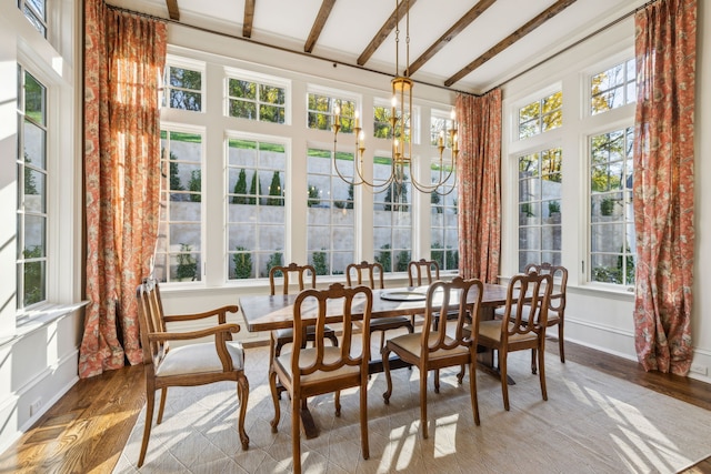 sunroom featuring beam ceiling and a chandelier