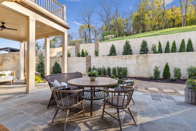 view of patio featuring ceiling fan and a balcony