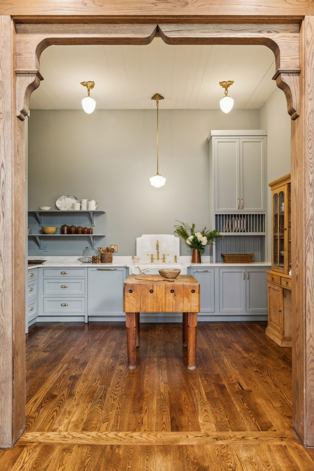 kitchen featuring sink, decorative light fixtures, dishwasher, and dark wood-type flooring