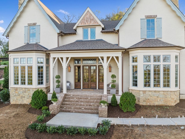 rear view of property featuring a porch and french doors