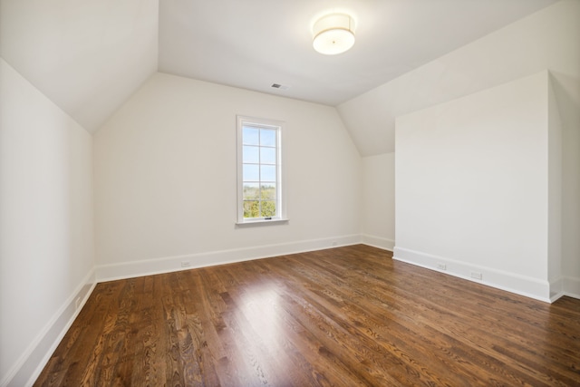 additional living space with dark hardwood / wood-style floors and vaulted ceiling