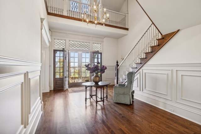 interior space featuring a notable chandelier, dark hardwood / wood-style flooring, and a high ceiling