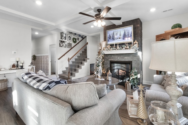 living room with coffered ceiling, ceiling fan, dark wood-type flooring, beam ceiling, and a fireplace