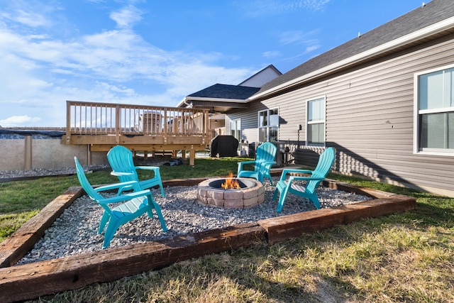 wooden terrace with area for grilling and an outdoor fire pit