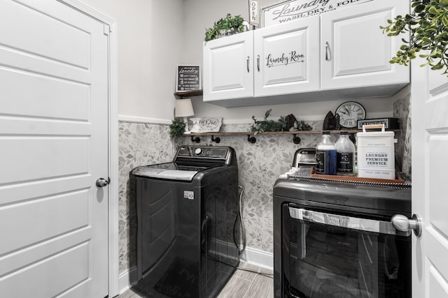 laundry area with washing machine and dryer and cabinets