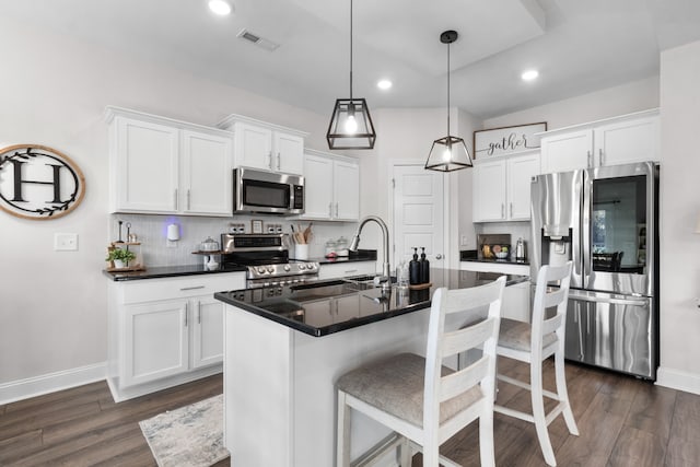 kitchen featuring pendant lighting, stainless steel appliances, white cabinetry, and sink