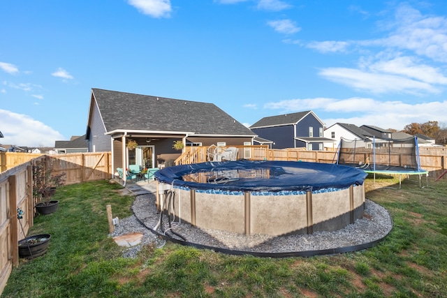 view of swimming pool featuring a yard and a trampoline