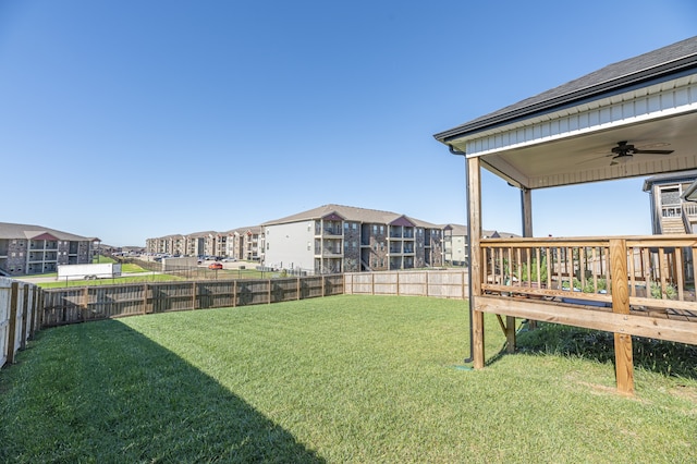 view of yard featuring a wooden deck and ceiling fan