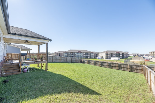 view of yard with ceiling fan and a deck