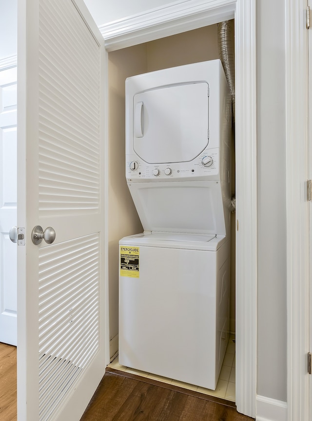 laundry area with hardwood / wood-style floors and stacked washing maching and dryer