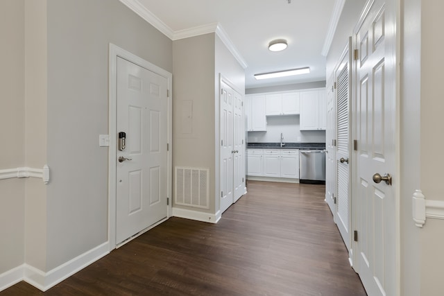 corridor featuring ornamental molding, dark wood-type flooring, and sink