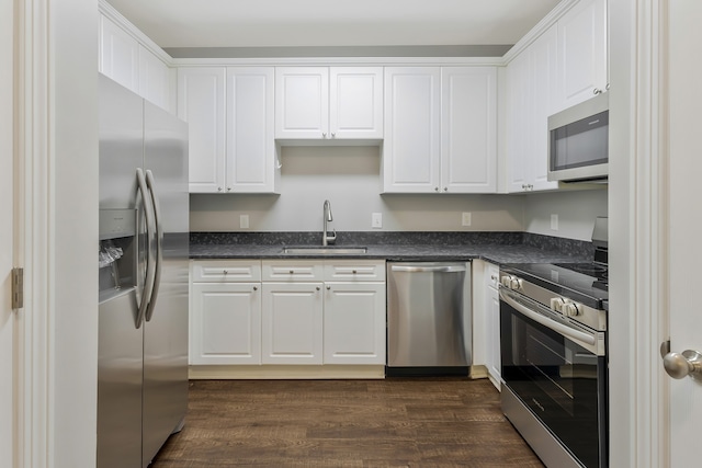 kitchen with stainless steel appliances, white cabinetry, and sink