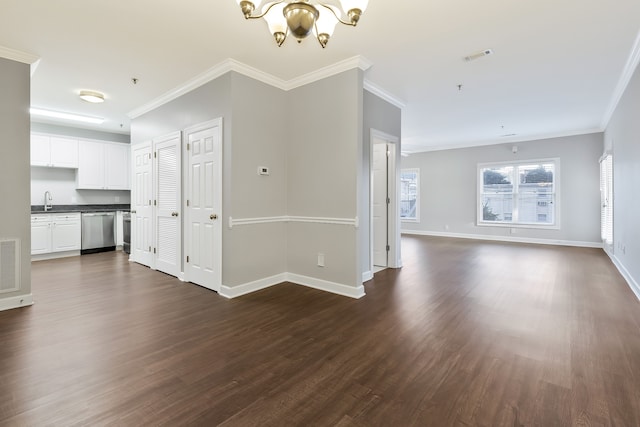 unfurnished living room featuring crown molding, sink, dark hardwood / wood-style floors, and an inviting chandelier