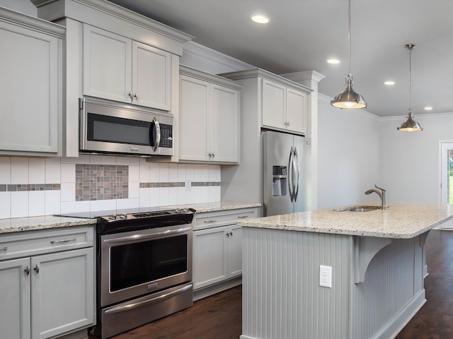 kitchen featuring light stone countertops, appliances with stainless steel finishes, dark wood-type flooring, sink, and hanging light fixtures