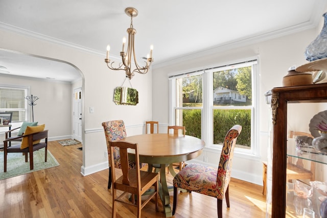 dining space featuring light wood-type flooring, plenty of natural light, and ornamental molding