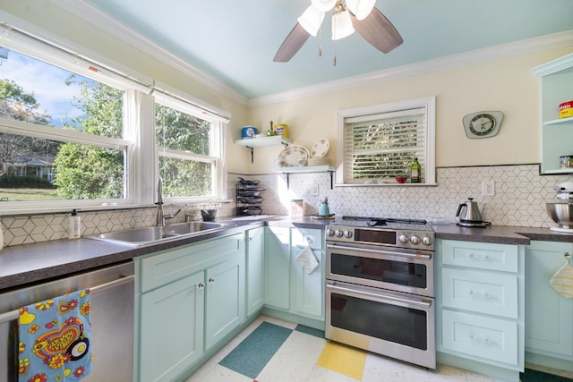 kitchen featuring ceiling fan, sink, backsplash, crown molding, and appliances with stainless steel finishes