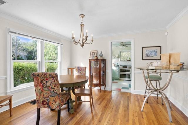 dining area featuring an inviting chandelier, ornamental molding, and light hardwood / wood-style flooring