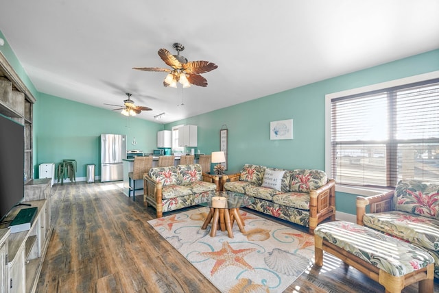 living room featuring dark hardwood / wood-style floors, ceiling fan, and vaulted ceiling