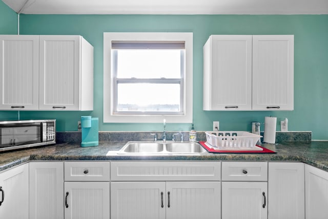 kitchen featuring white cabinetry and sink