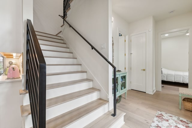 stairs featuring hardwood / wood-style floors