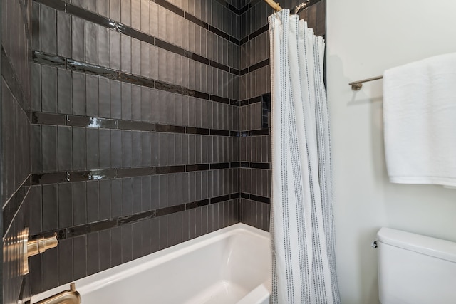 bathroom featuring shower / tub combo and toilet