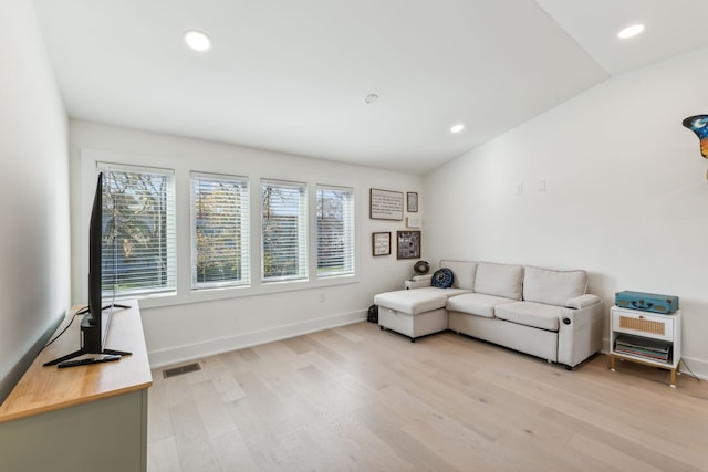 living room featuring light hardwood / wood-style floors and lofted ceiling