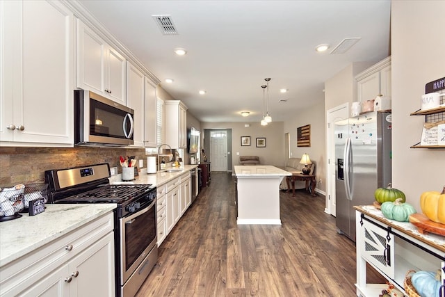 kitchen featuring white cabinetry, sink, hanging light fixtures, dark hardwood / wood-style floors, and appliances with stainless steel finishes