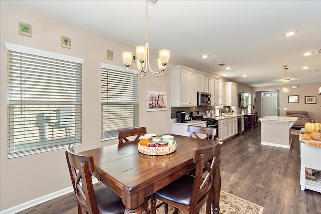 dining space featuring dark hardwood / wood-style flooring, an inviting chandelier, and sink