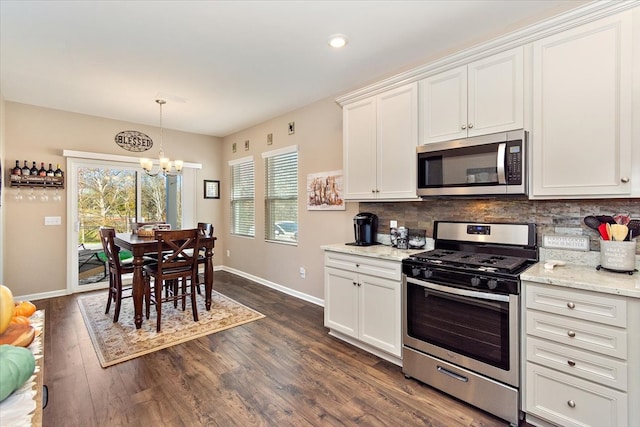 kitchen featuring an inviting chandelier, light stone countertops, dark hardwood / wood-style flooring, white cabinetry, and stainless steel appliances