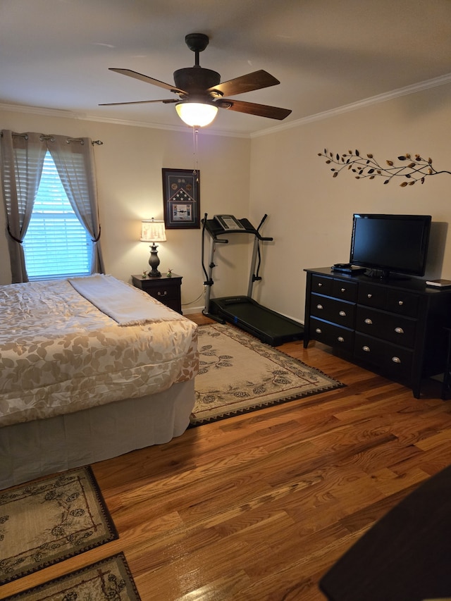 bedroom with hardwood / wood-style floors, ceiling fan, and ornamental molding