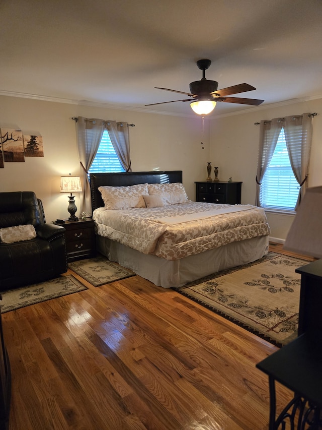 bedroom featuring hardwood / wood-style floors, ceiling fan, and crown molding