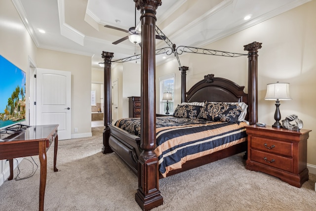 bedroom featuring connected bathroom, ceiling fan, light colored carpet, a tray ceiling, and ornamental molding