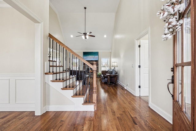 entrance foyer with ceiling fan, dark hardwood / wood-style floors, crown molding, and high vaulted ceiling