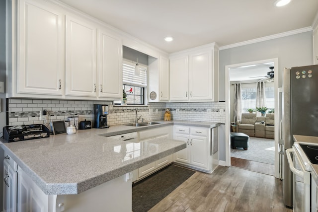 kitchen with white cabinets, light wood-type flooring, sink, and ornamental molding