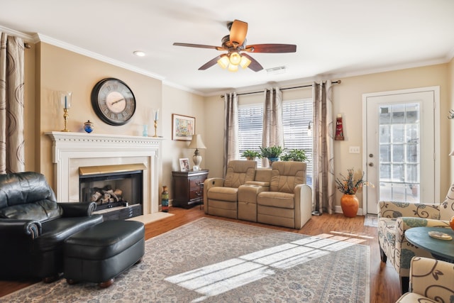 living room featuring wood-type flooring, ceiling fan, and ornamental molding