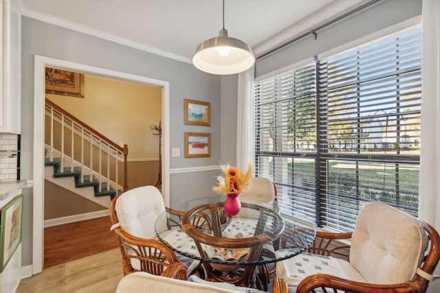 dining area featuring ornamental molding and light hardwood / wood-style flooring