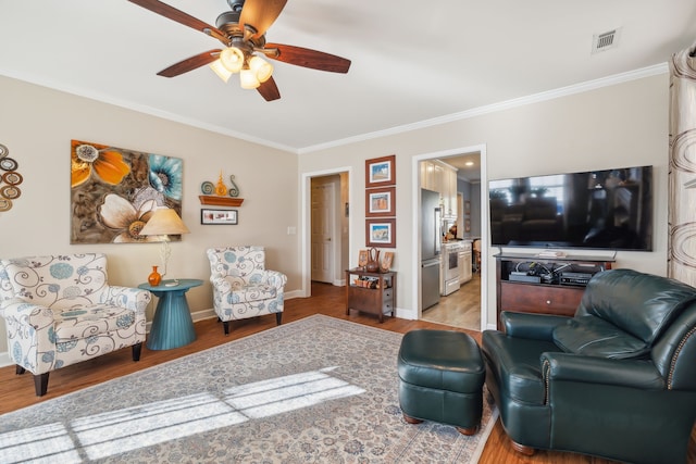 living room featuring ceiling fan, light hardwood / wood-style flooring, and ornamental molding