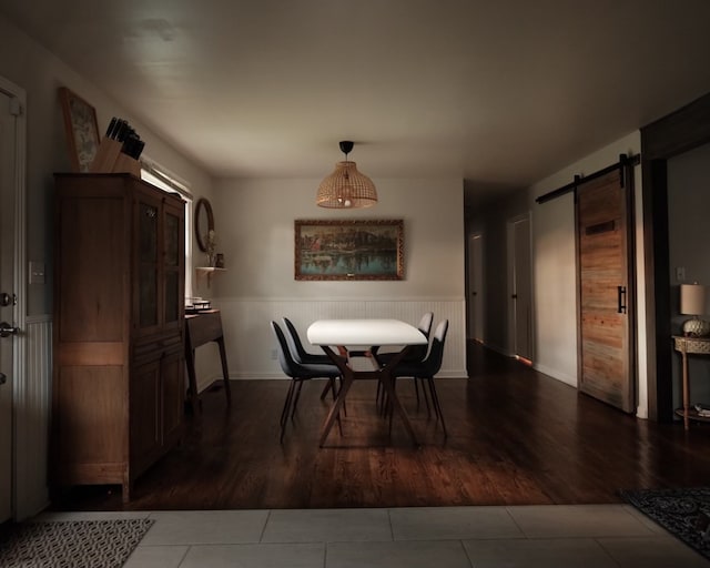 dining area with dark hardwood / wood-style floors and a barn door