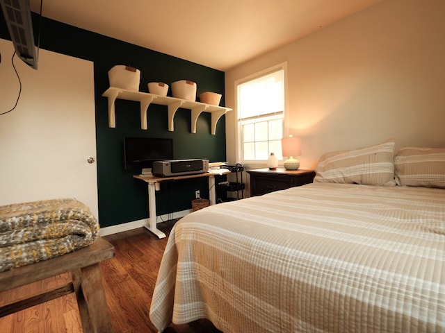 bedroom with dark hardwood / wood-style floors