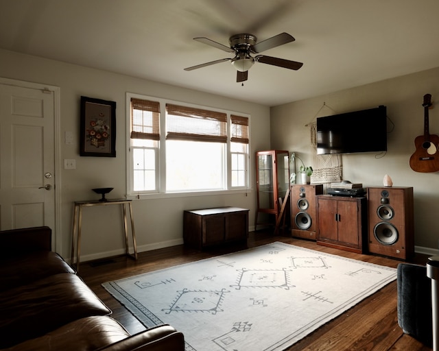 living room with ceiling fan and dark wood-type flooring