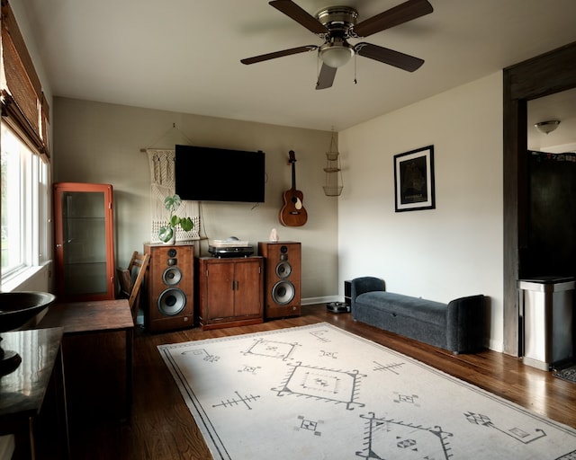 living room with ceiling fan and dark wood-type flooring