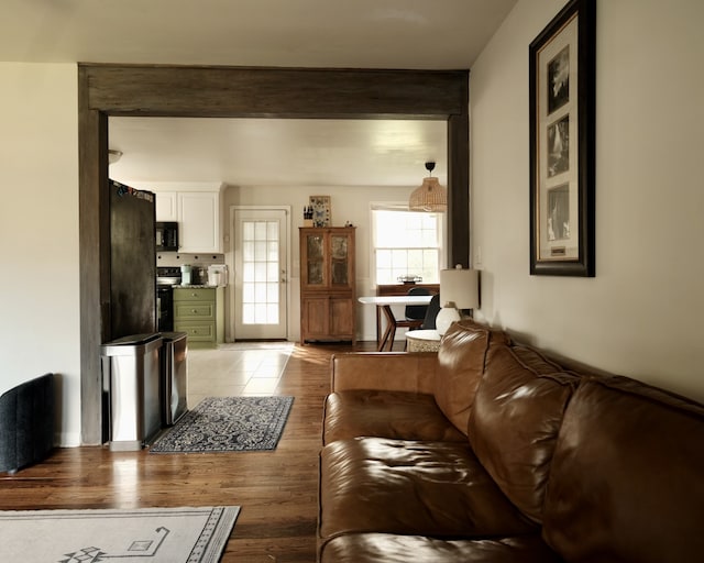 living room featuring beamed ceiling and light hardwood / wood-style flooring