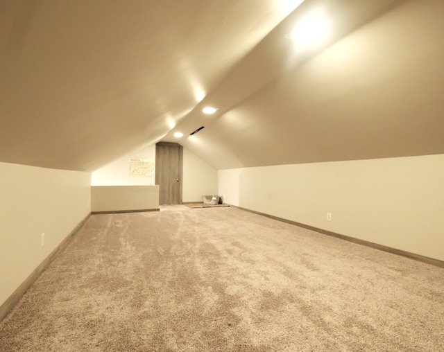 additional living space featuring carpet flooring and lofted ceiling