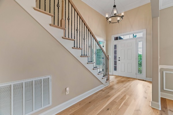 entryway with a chandelier, hardwood / wood-style floors, and ornamental molding