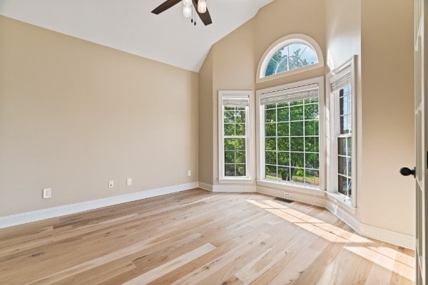 empty room featuring ceiling fan, light hardwood / wood-style floors, and high vaulted ceiling