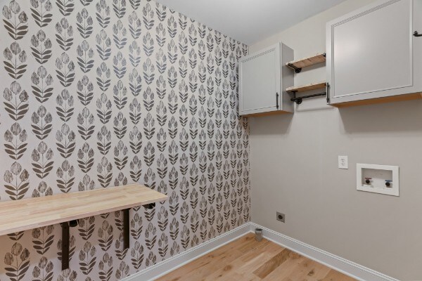 laundry area featuring light hardwood / wood-style floors, hookup for an electric dryer, cabinets, and washer hookup