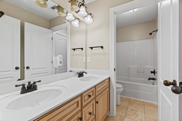 full bathroom with toilet, vanity, tile patterned floors, and shower / bathtub combination