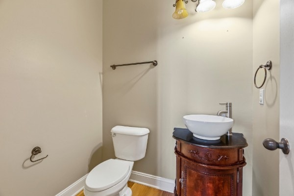 bathroom featuring vanity, wood-type flooring, and toilet