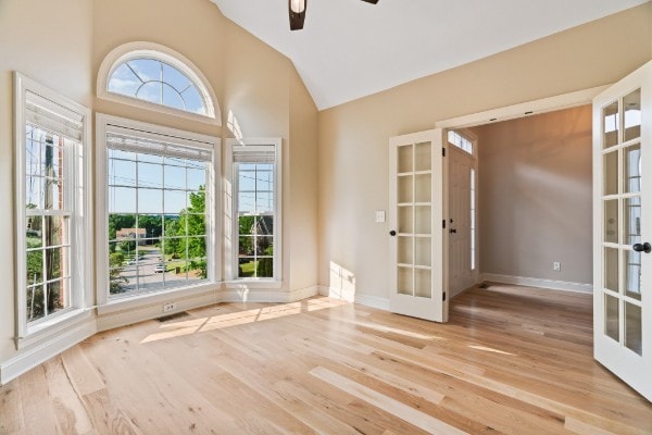 interior space with french doors, light wood-type flooring, ceiling fan, and lofted ceiling