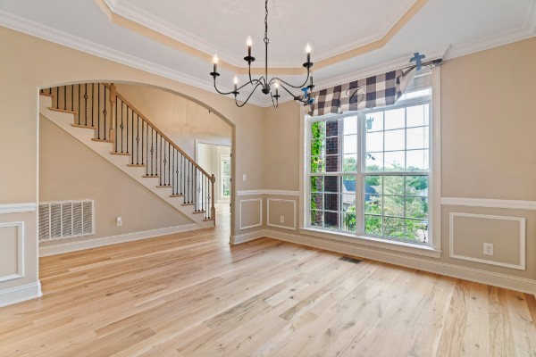 interior space featuring wood-type flooring, a tray ceiling, a wealth of natural light, and crown molding